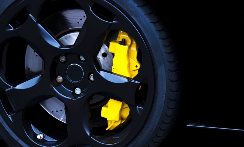 Black alloy wheel with yellow carbon ceramic brake, copy space