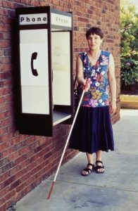 A visually impaired woman using a walking stick
