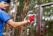worker installing metal fence
